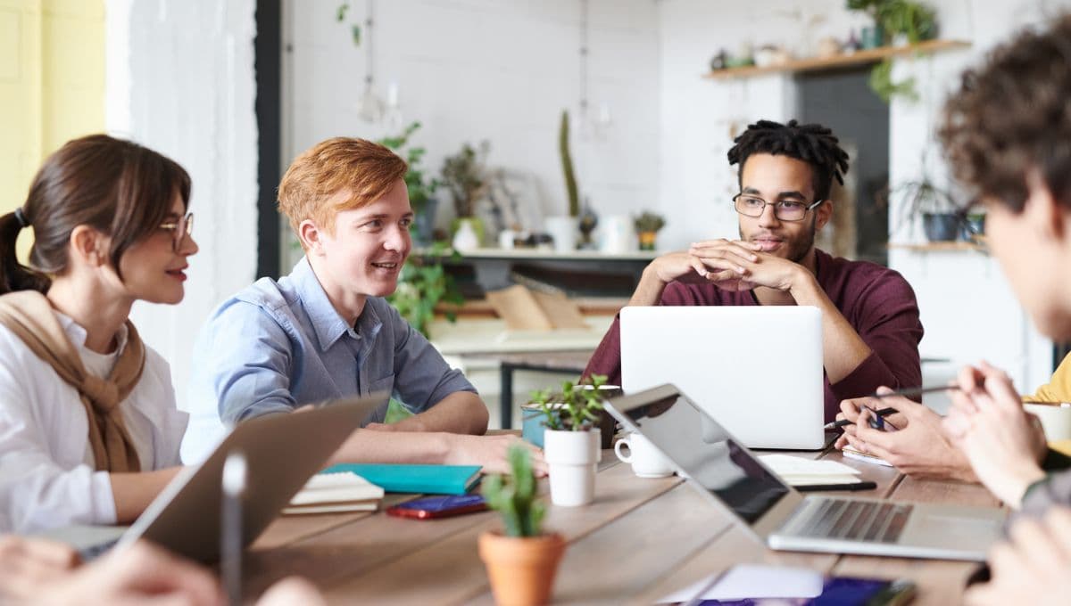 A diverse team collaborating with laptops in a bright modern office