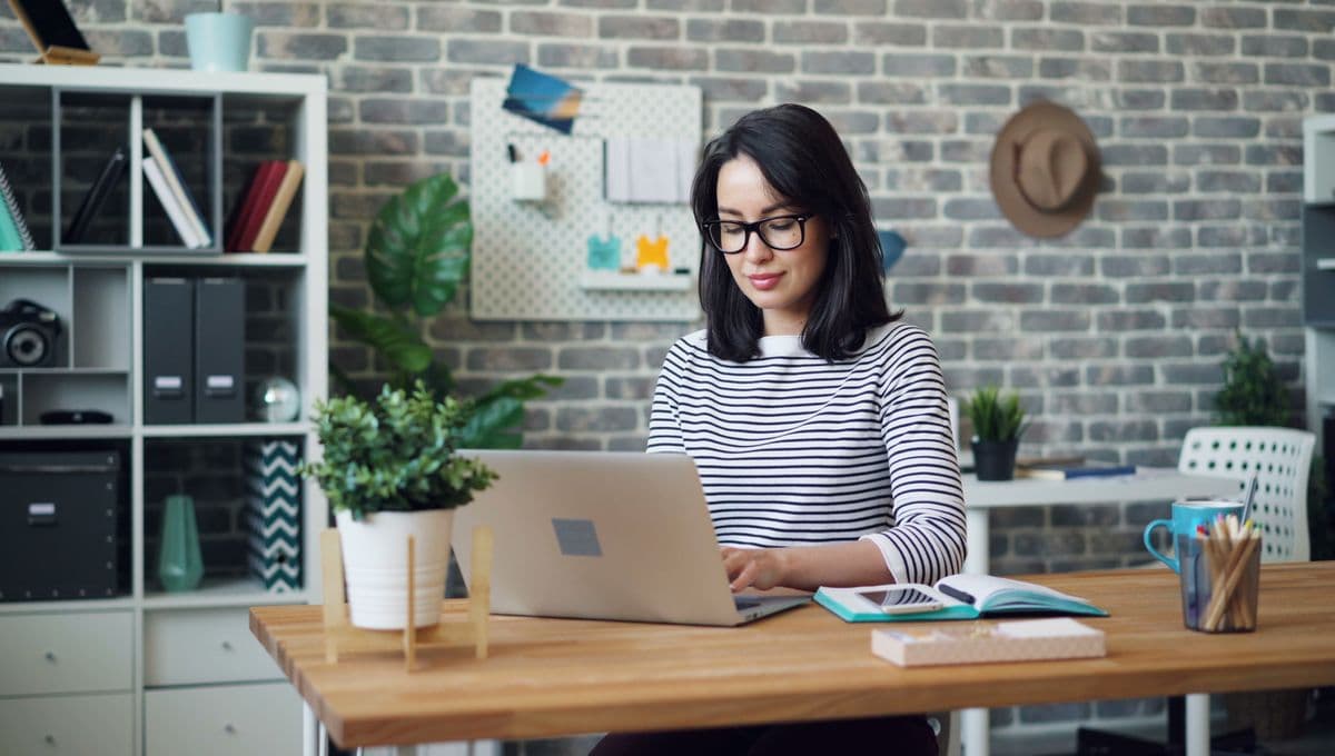 A person working at a laptop in a bright modern office